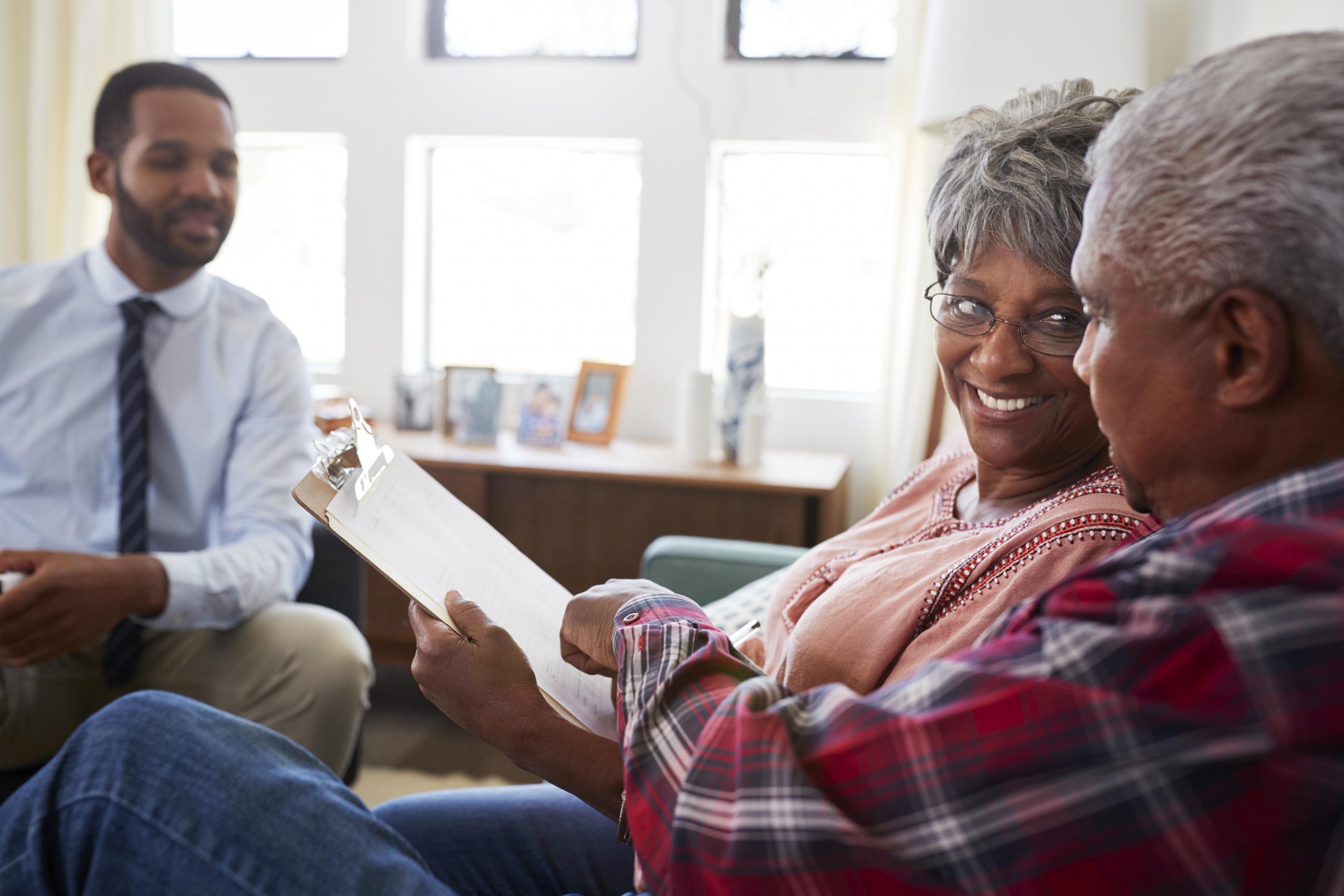 Senior Couple Meeting With Male Financial Advisor At Home
